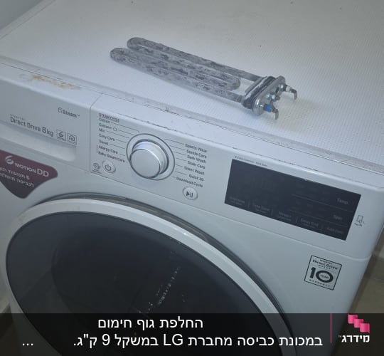 מכונת כביסה עם חלק חילוף מונח עליה